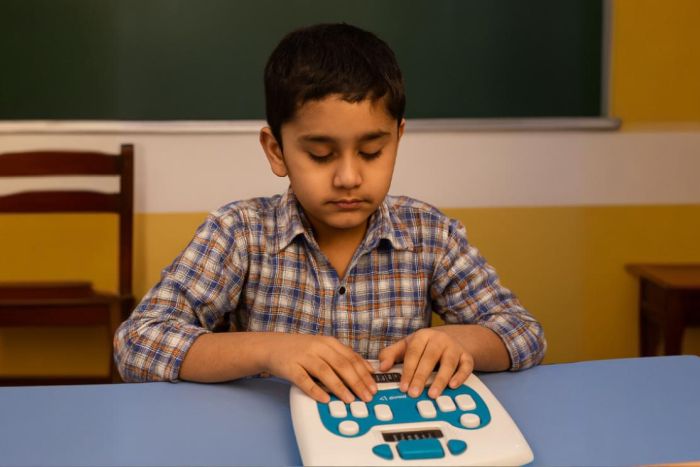 Child who is blind learning Braille on a Annie self learning Braille device