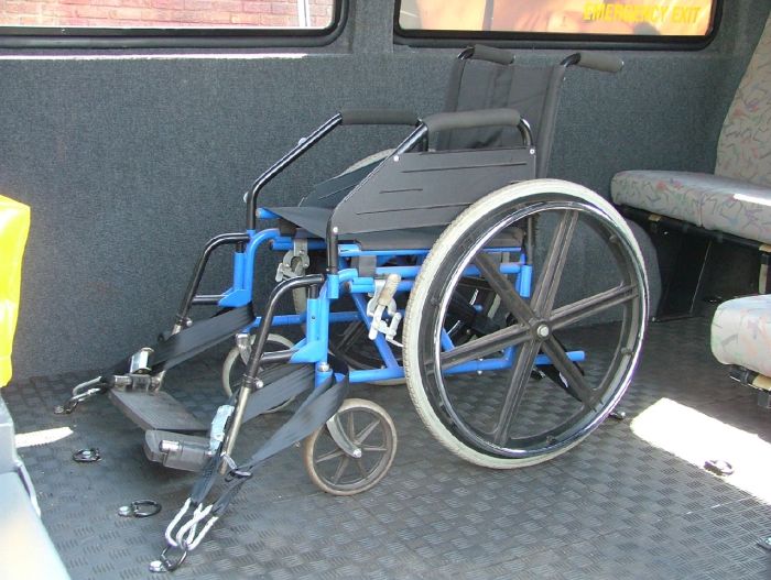 A wheelchair tied down to a vehicle using a tie-down system