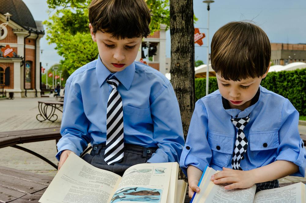 Two little boys sit reading
